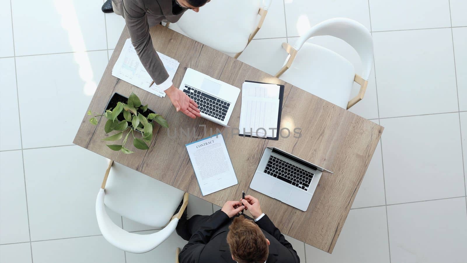 Two successful smiling businessmen are working on a laptop. view from above by Prosto