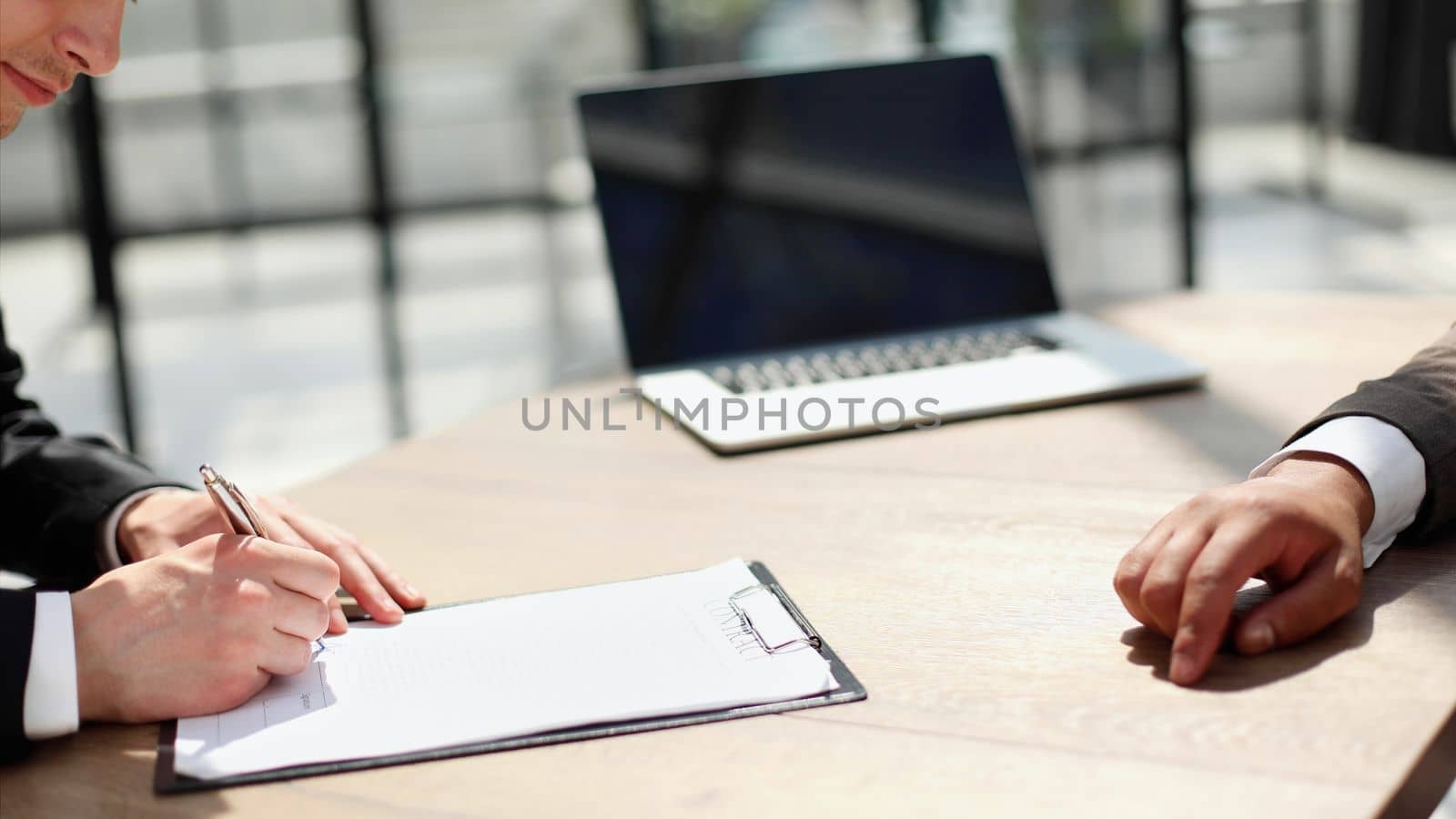 Businessmen hand's pointing where to sign a contract, legal papers or application form.