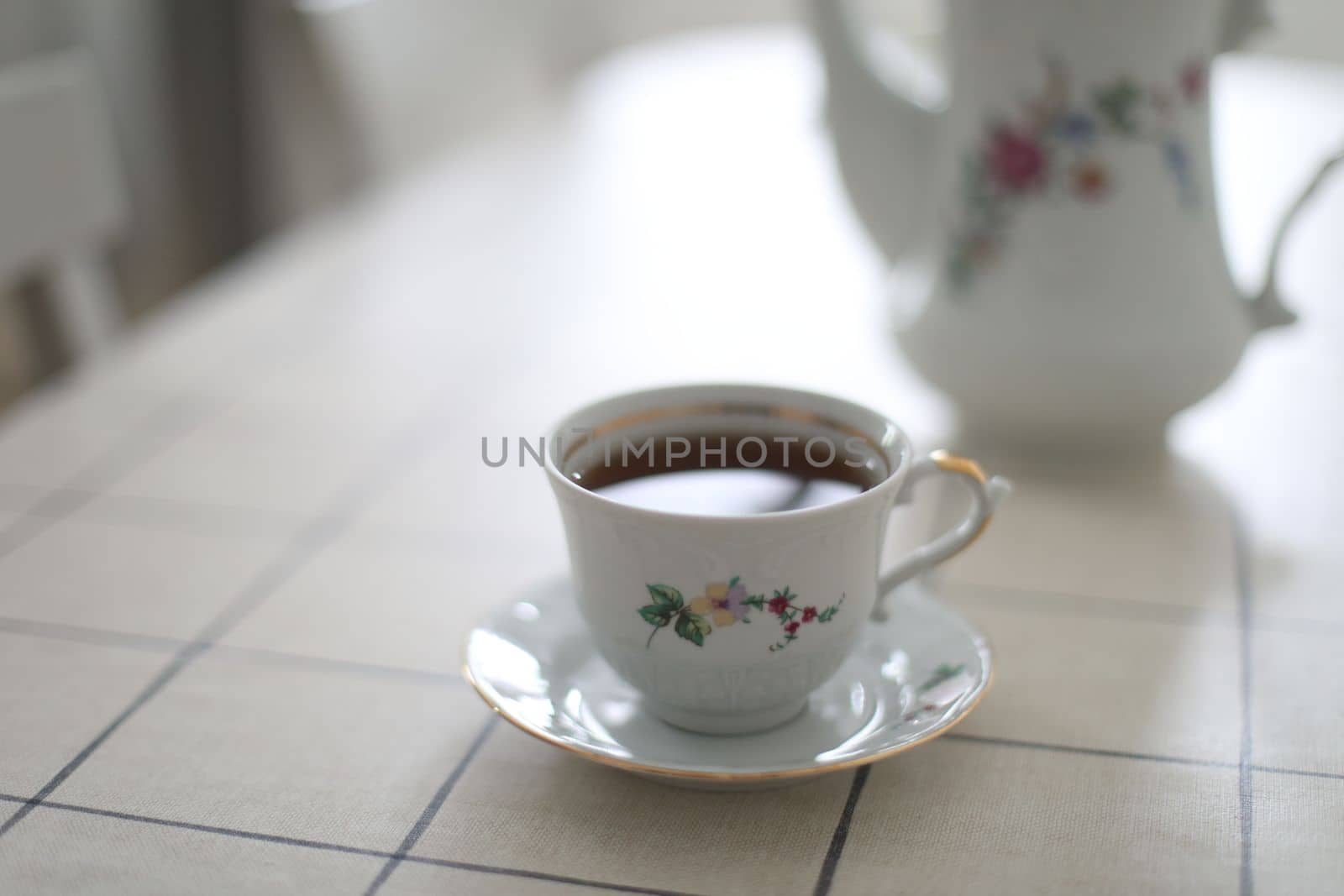 antique porcelain tea set on white background. cup of tea and a kettle on a table.