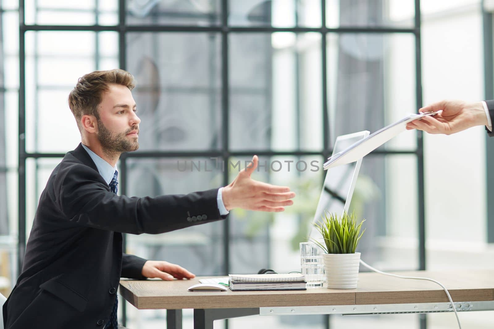 Businessman Taking Papers From Secretary In Office