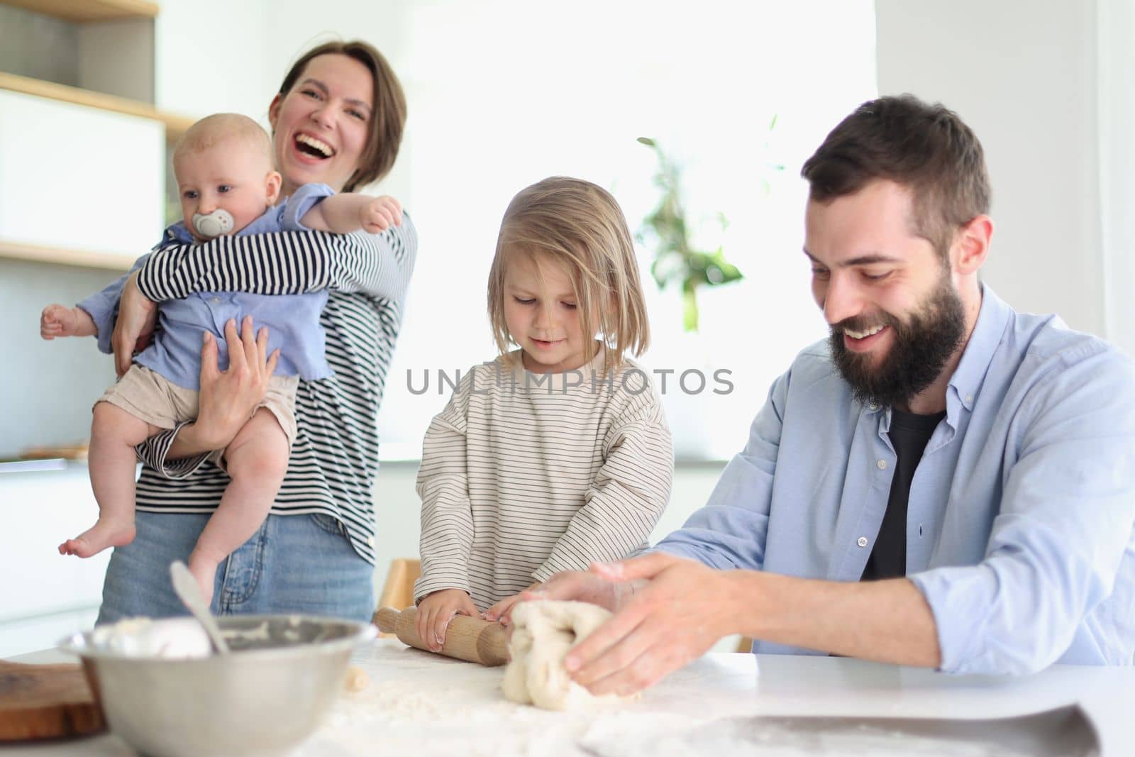 Young family with daughter and son in the kitchen