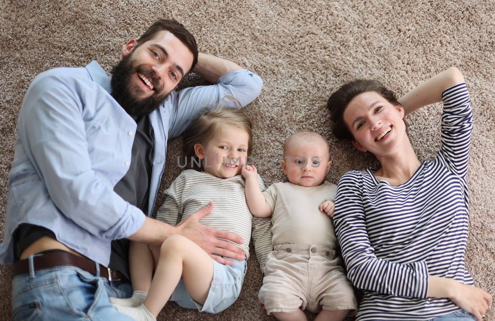 happy family mother father and kids at home. laying