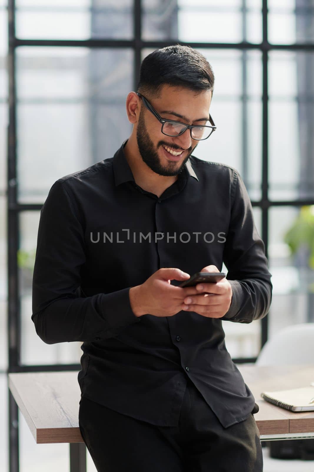 Young casual Businessman holding and using smartphone for sms messages by Prosto