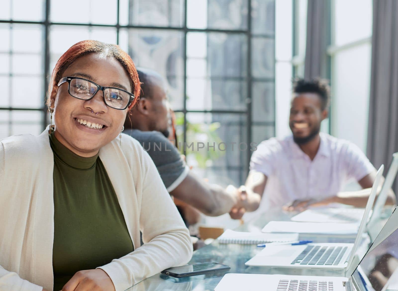 Portrait Of Businesswoman In Modern Open Plan Office With Business Team Working In Backgroun