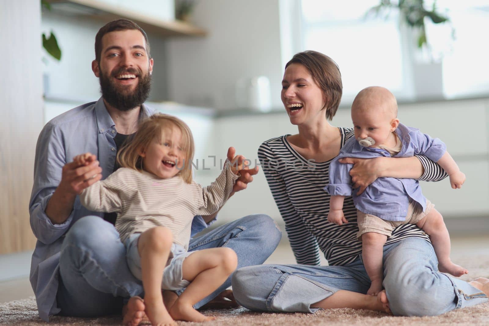 Happy parents playing with children in the kitchen