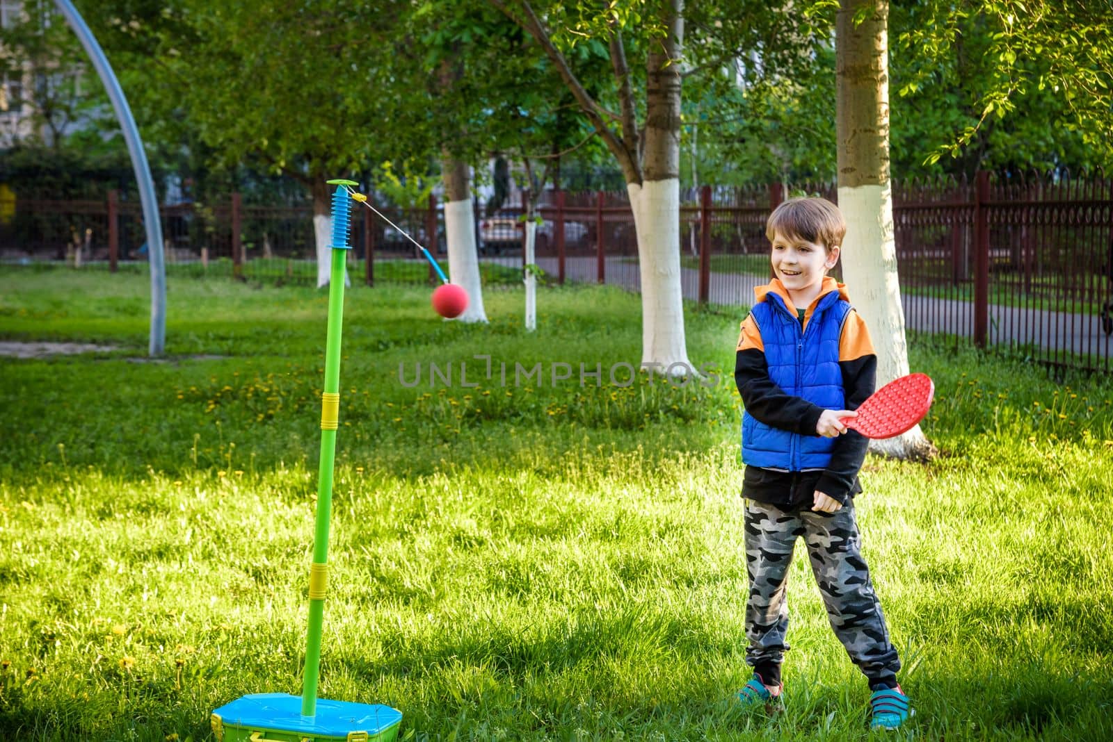 Happy boy is playing tetherball swing ball game in summer camping. Happy leisure healthy active time outdoors concept.