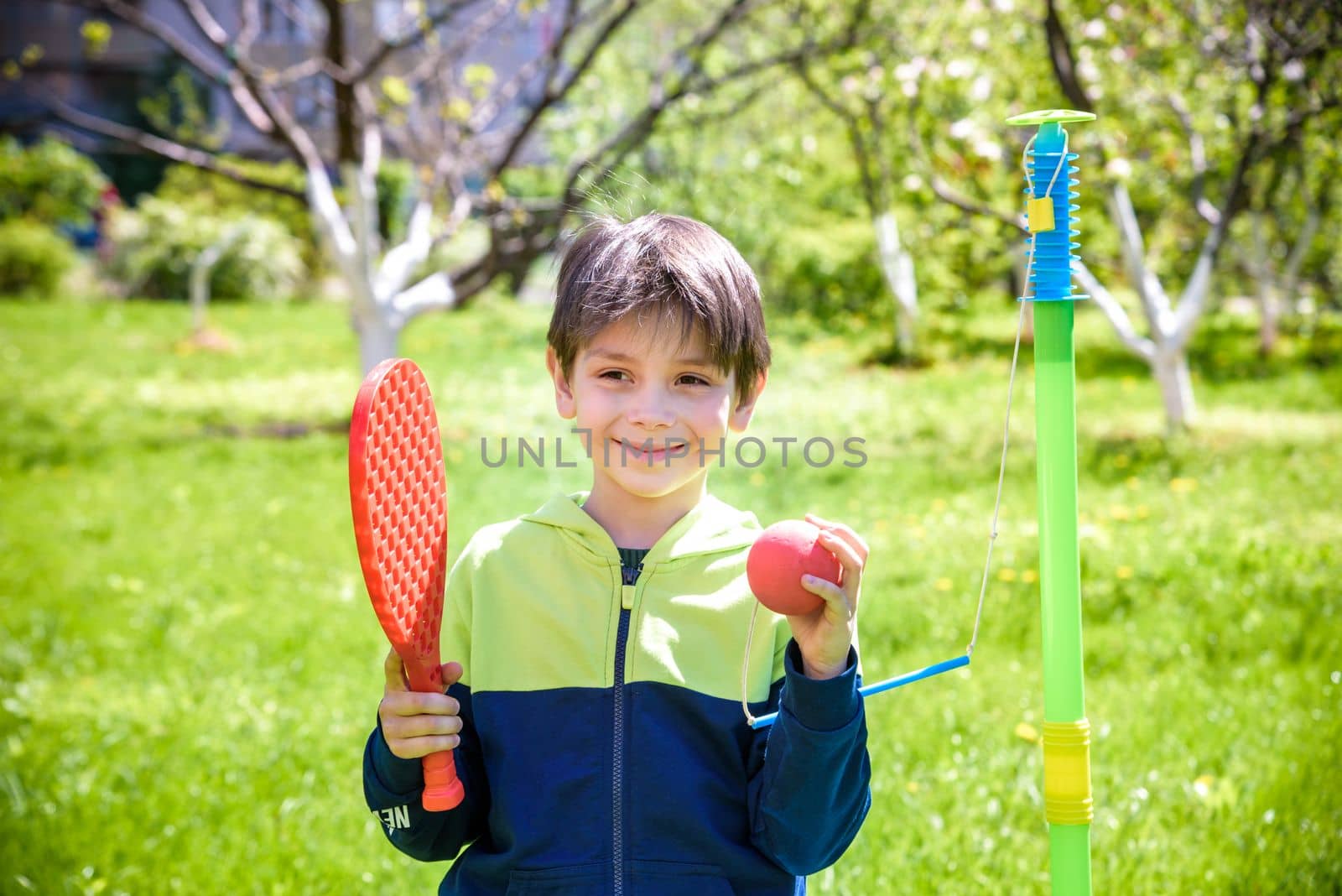 Happy boy is playing tetherball swing ball game in summer camping. Happy leisure healthy active time outdoors concept.