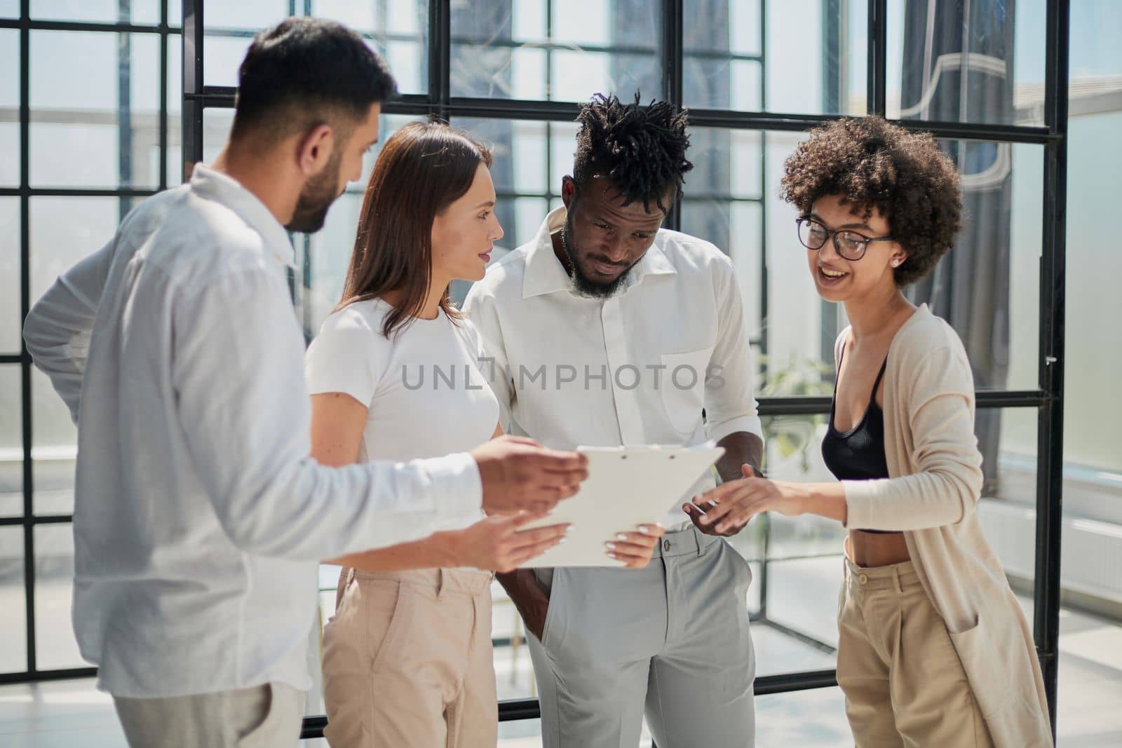 Happy young female employee discussing online project, showing computer presentation to skilled team leader in eyeglasses. Friendly diverse colleagues working in pairs on laptop, using applications.