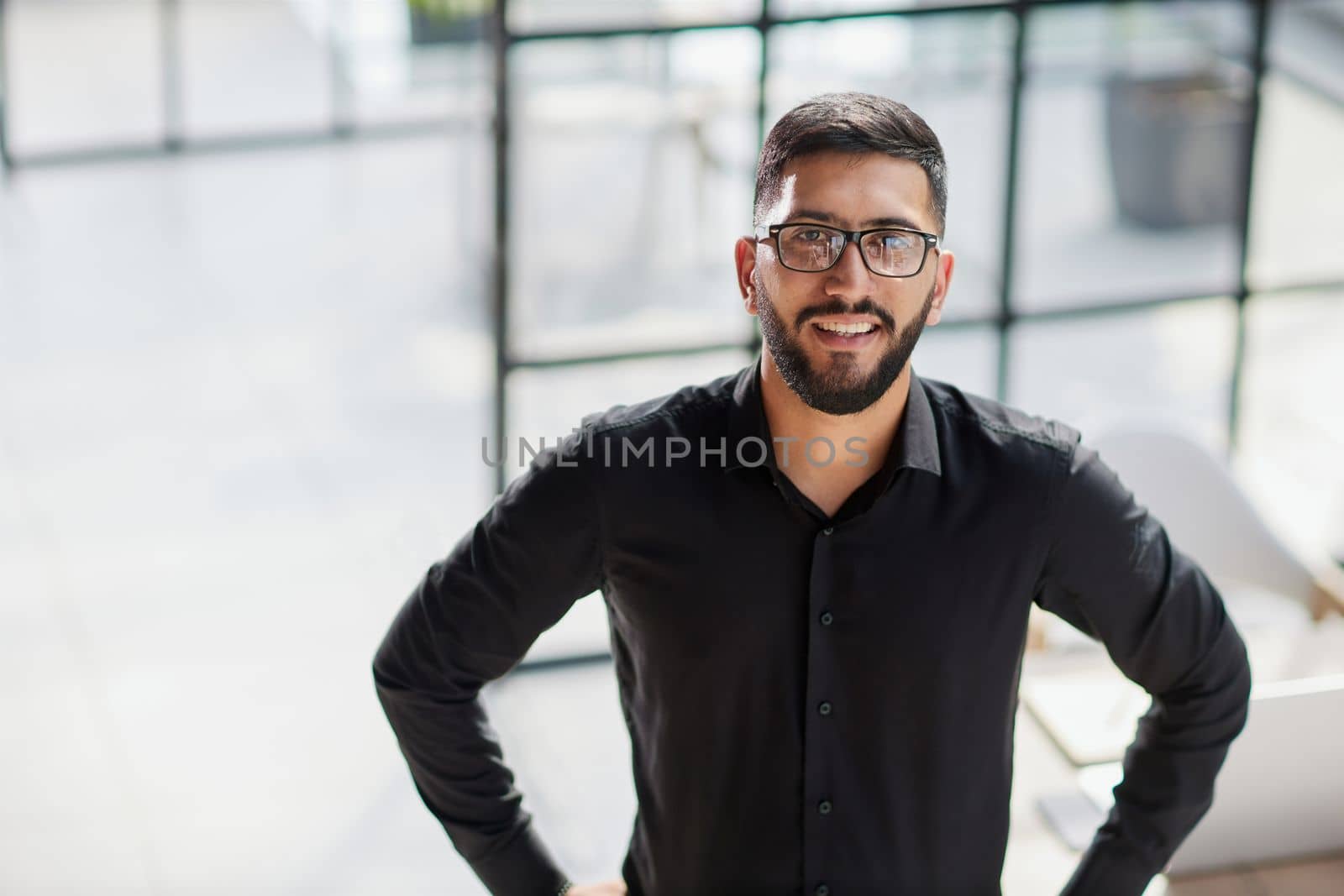 Businessman portrait. Happy confident young businessman standing , smiling, looking at camera.