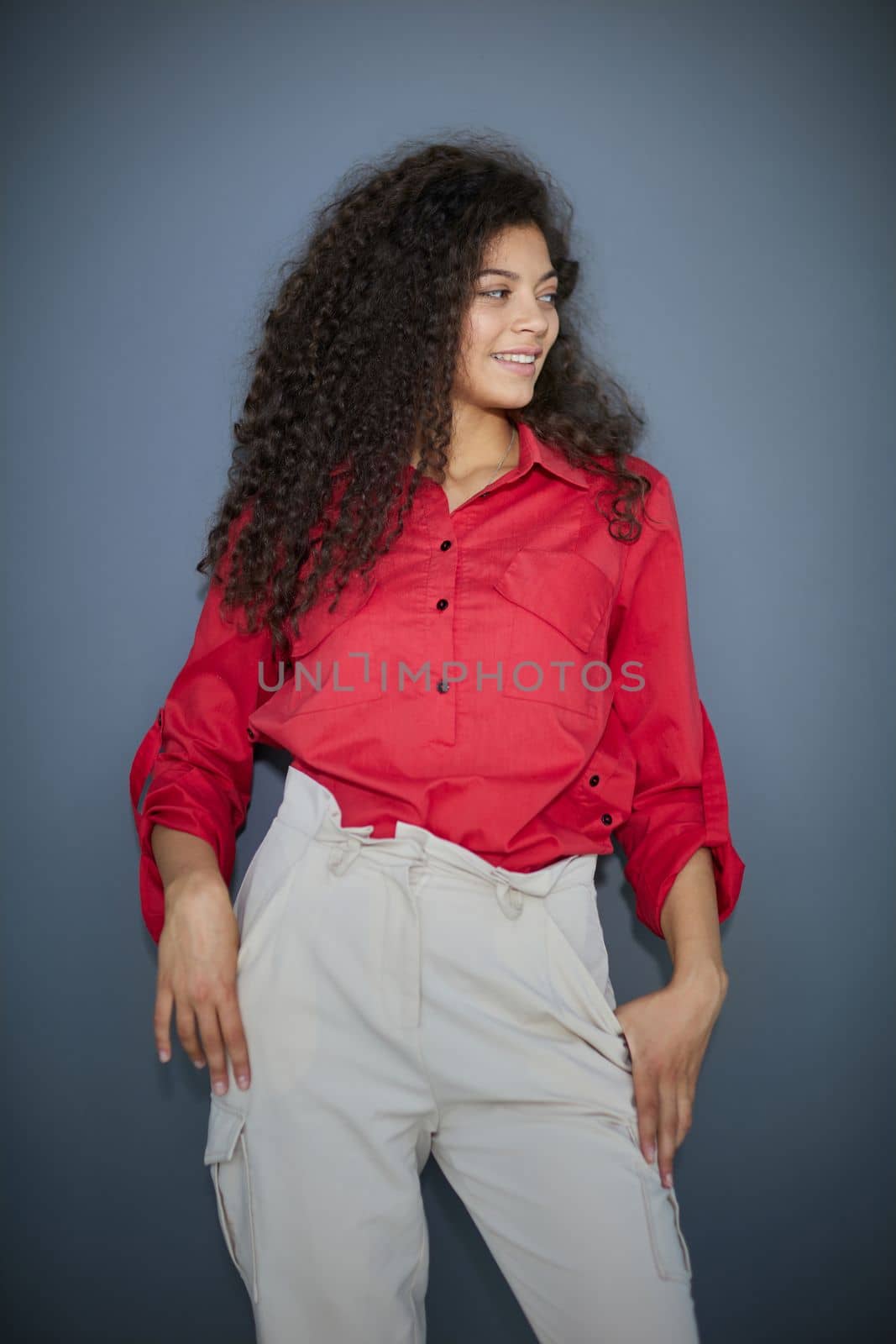 Happy young business woman posing isolated over grey wall background.