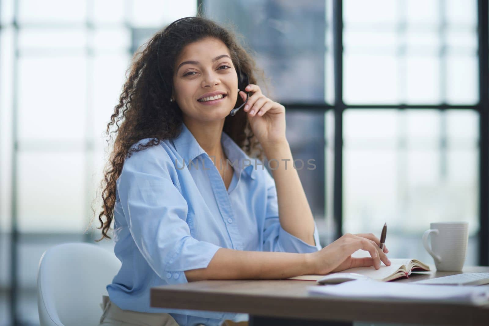 Portrait of an attractive cheerful experienced girl advising clients on customer service in the office