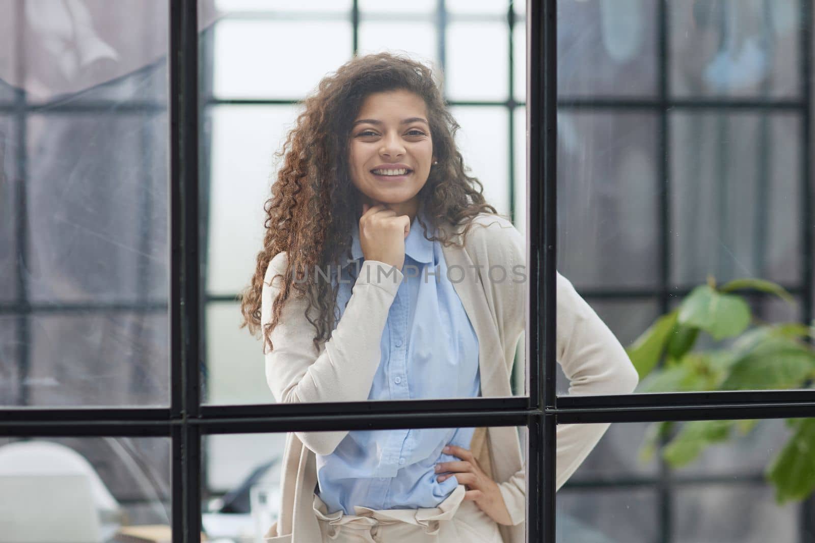 from behind the glass. young business woman thinking about something