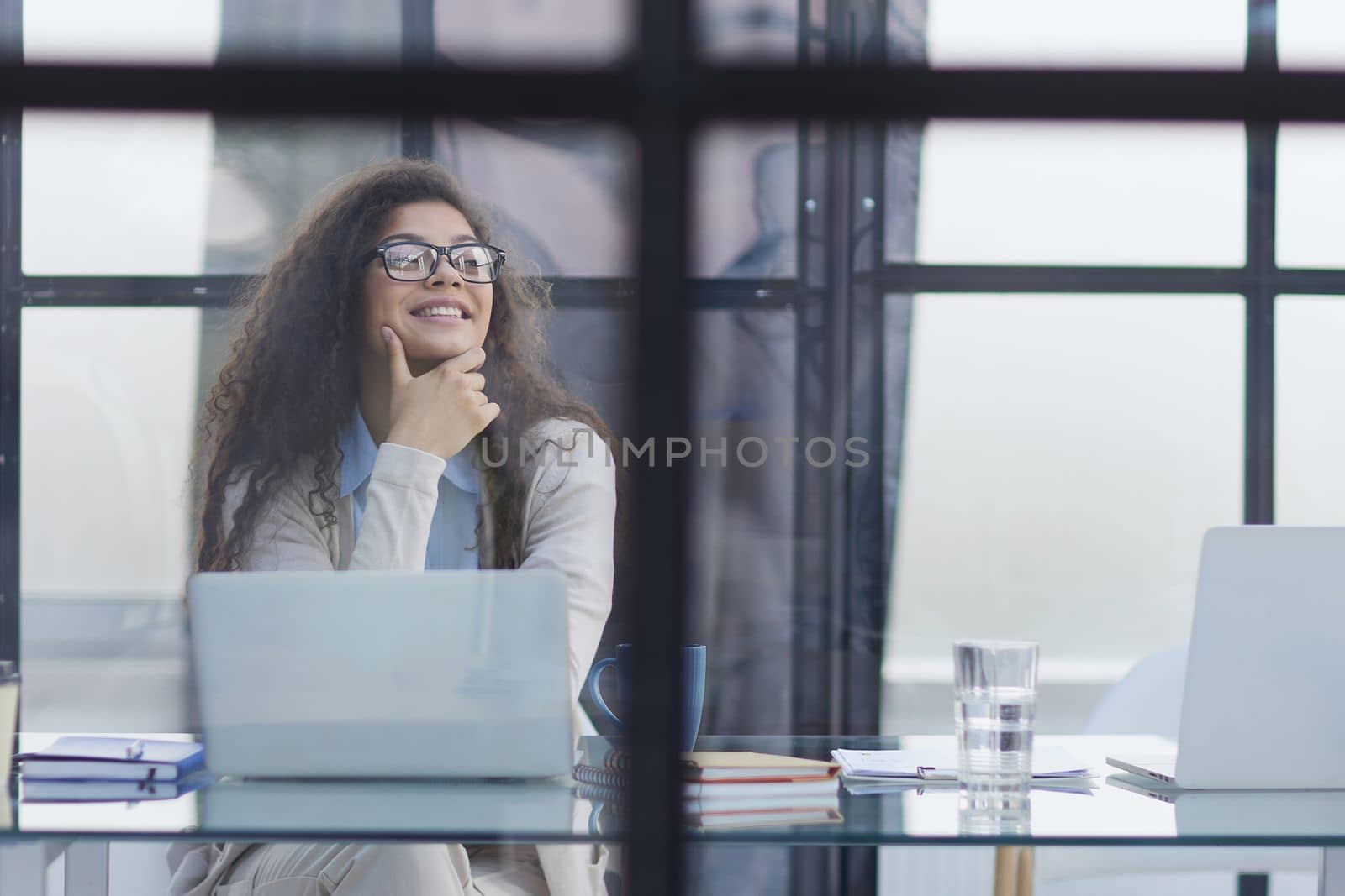 Young businesswoman using laptop at table in office