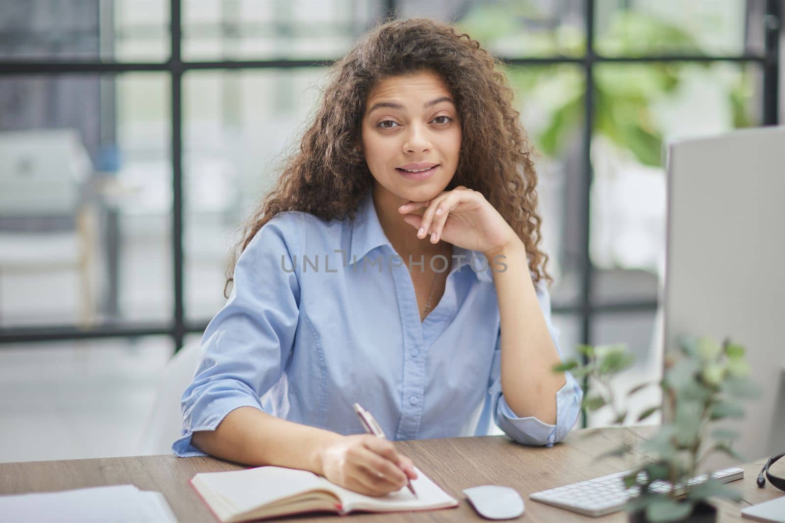 Business woman holding pens and papers making notes in documents on the table