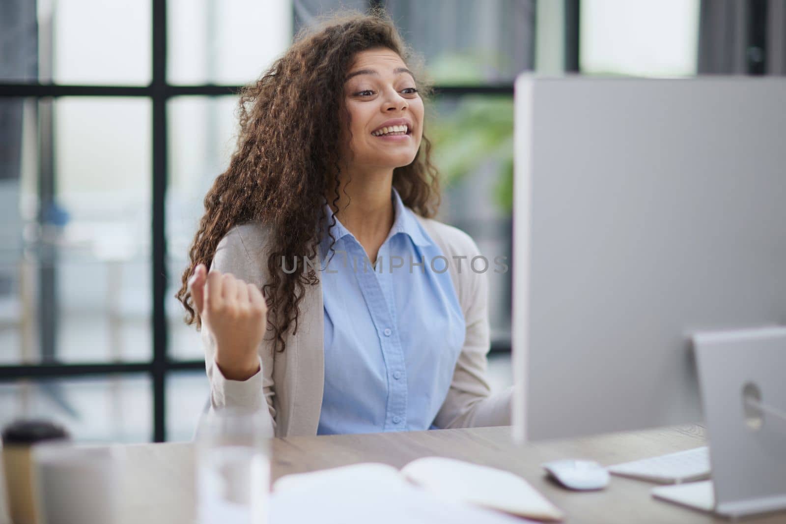expressive young woman open mouth checking discounts for online shopping sitting at desktop .