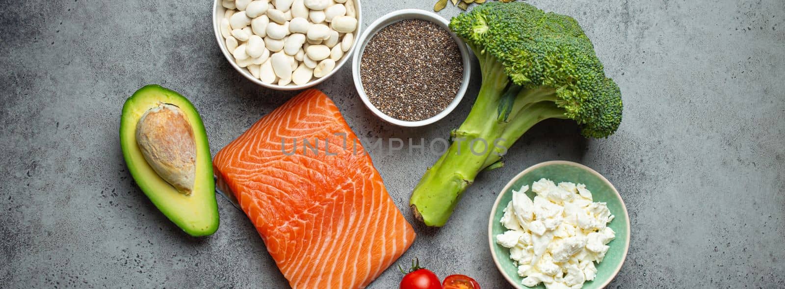 Selection of healthy food products if a person have diabetes: salmon fish, broccoli, avocado, beans, vegetables, seeds on grey background from above. Healthy diabetes diet by its_al_dente
