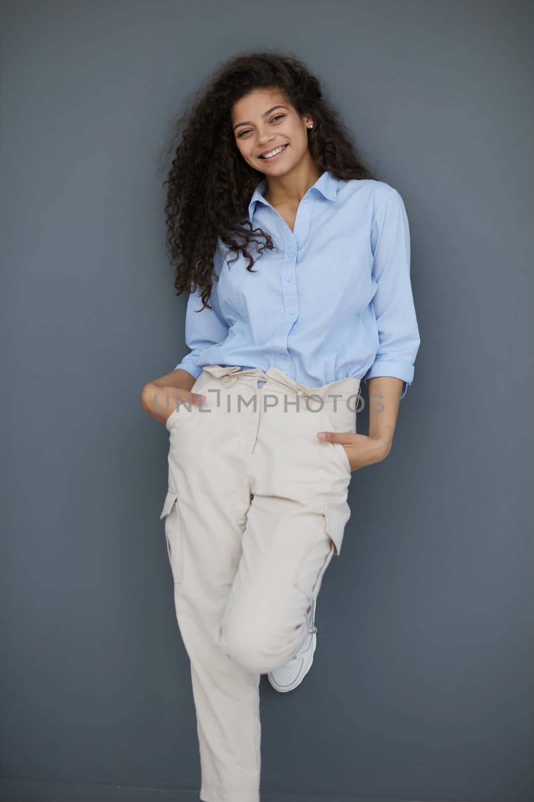 Photo of cheerful self-assured lady folded arms wear blue shirt grey color background