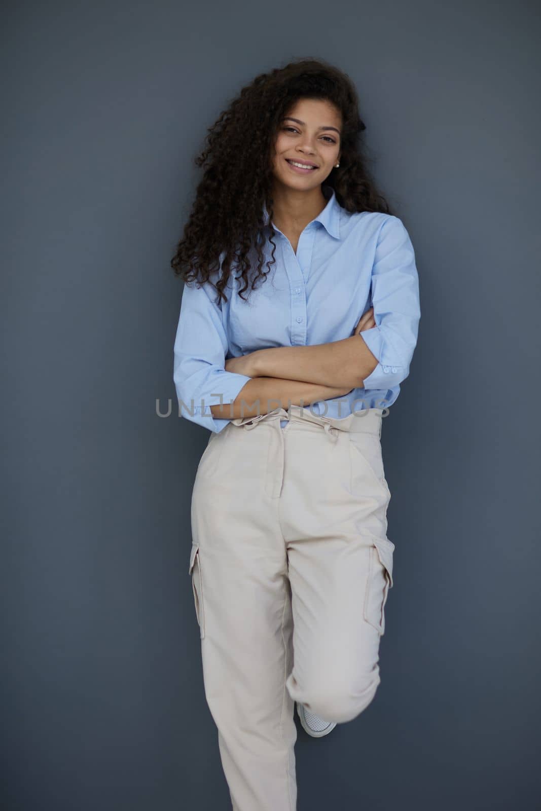 Photo of cheerful self-assured lady folded arms wear blue shirt grey color background