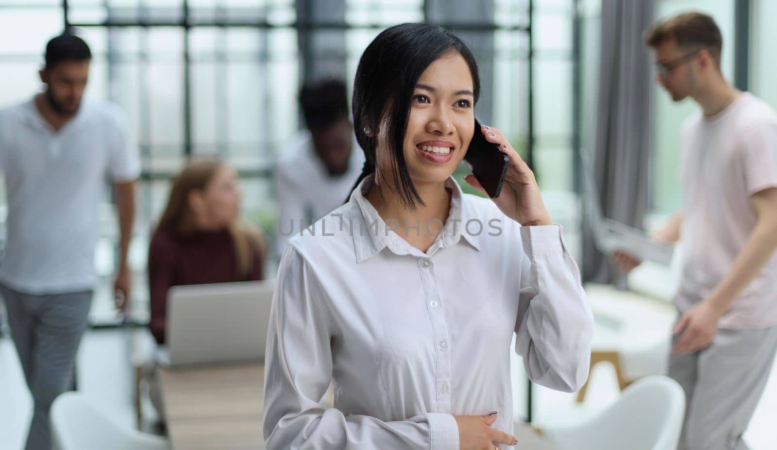 young asian business lady in white shirt talking on the phone in the office