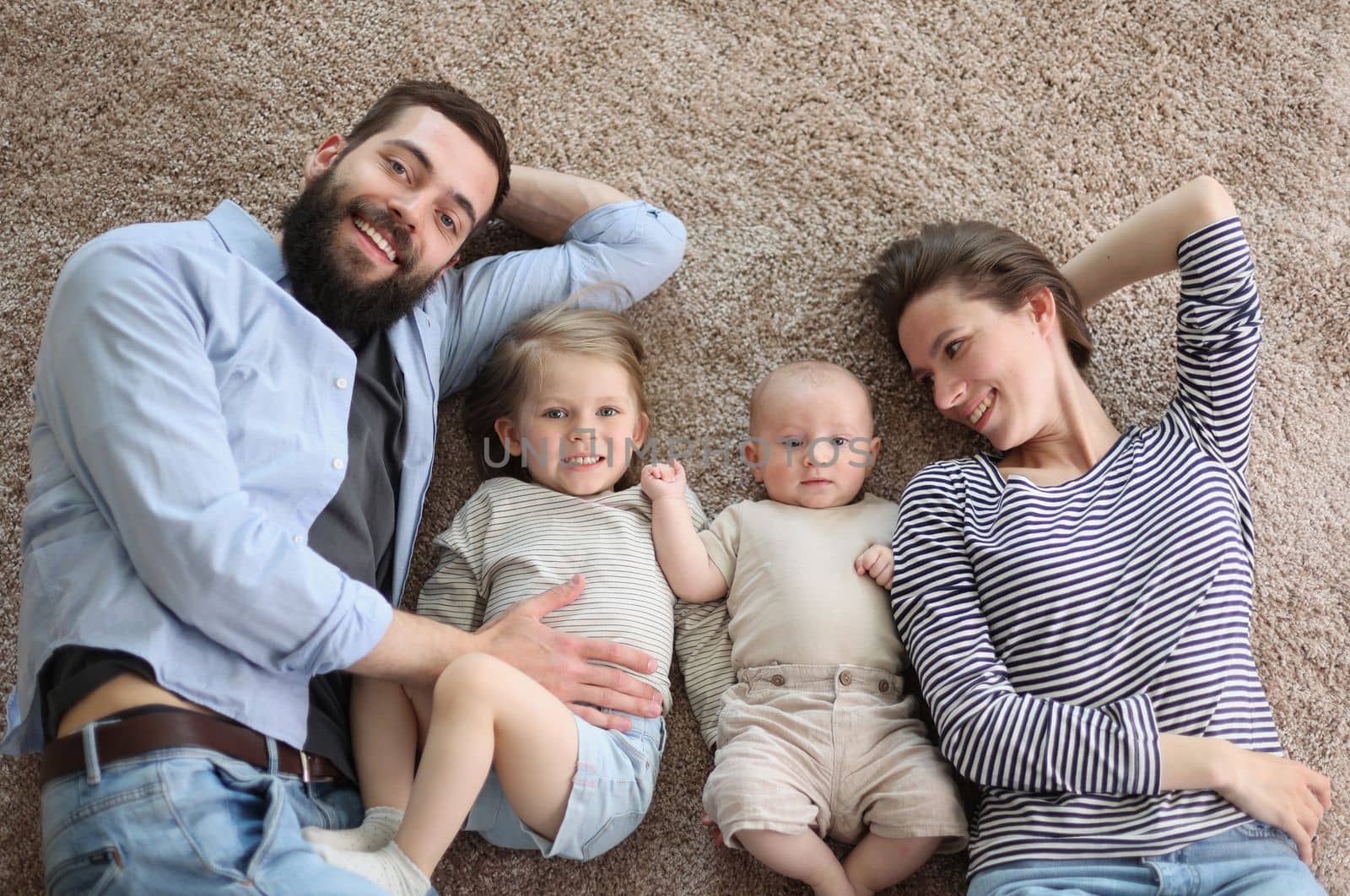 happy family mother father and kids at home. laying