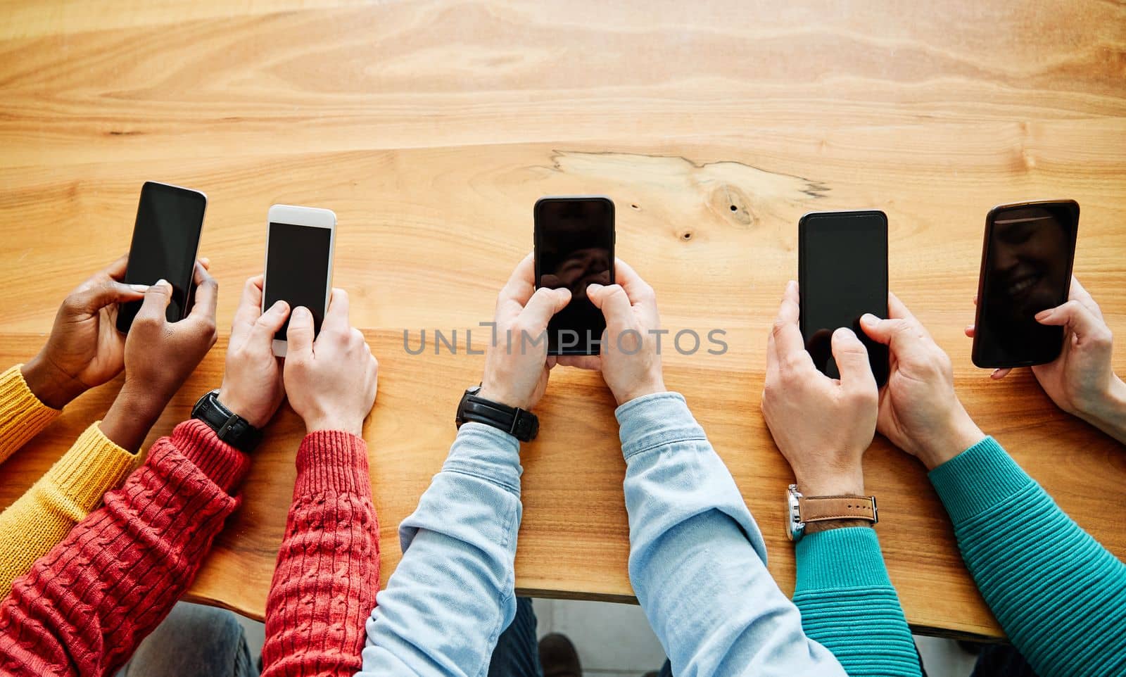 close up shot of a group of young people using their smart phones in synchronicity