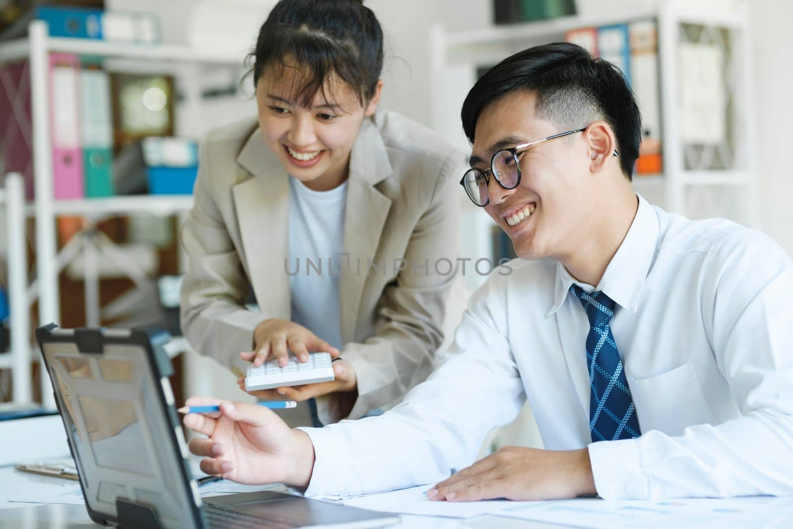 Businesspeople or colleagues are working together on investment project, discussing, sharing ideas, planning, and analyzing the business strategy and finance using laptop computer.