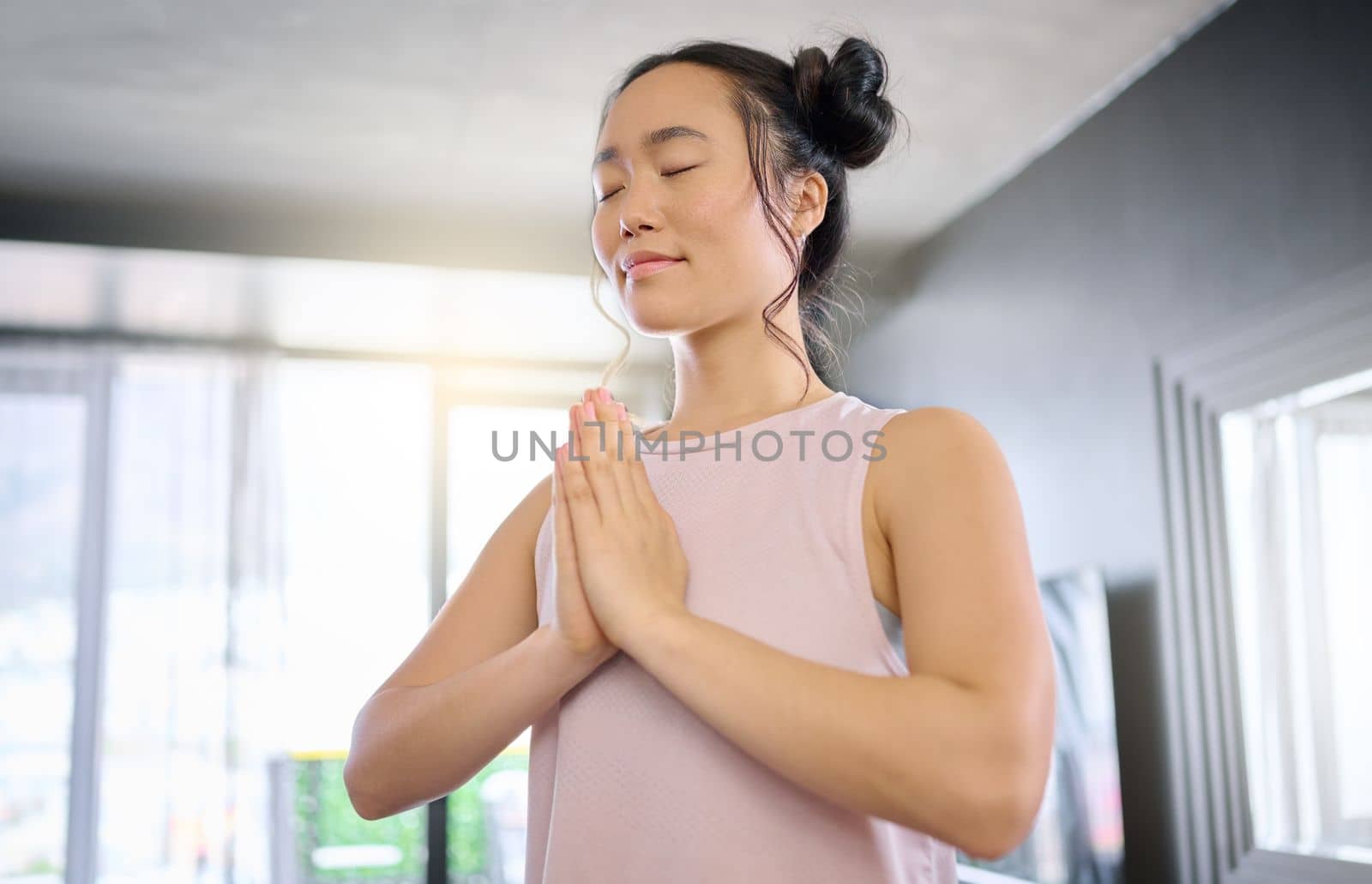 Yoga, meditation and praying woman training her mind for peace, zen and calm start to the morning. Hope, freedom and Asian girl in the living room for a mindset exercise, spiritual and mindfulness.