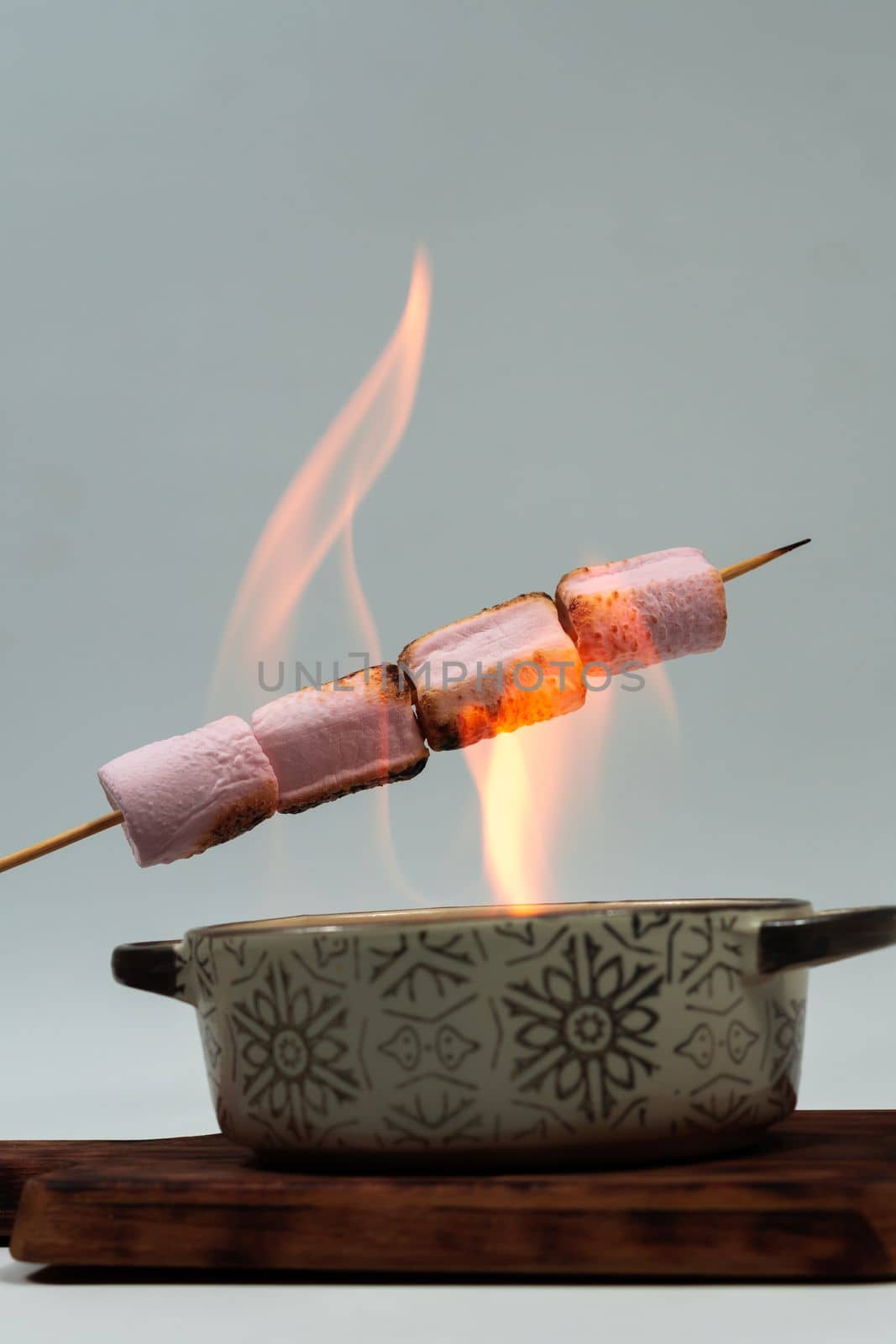 skewer of sweet marshmallows warming on the fire