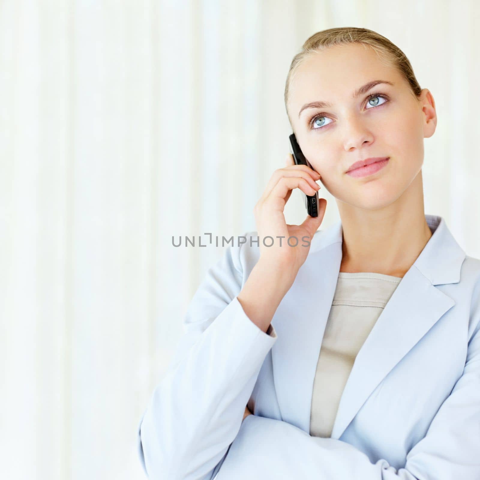 Cute business woman having a conversation over cellphone. Young pretty business woman speaking over the cellphone. by YuriArcurs