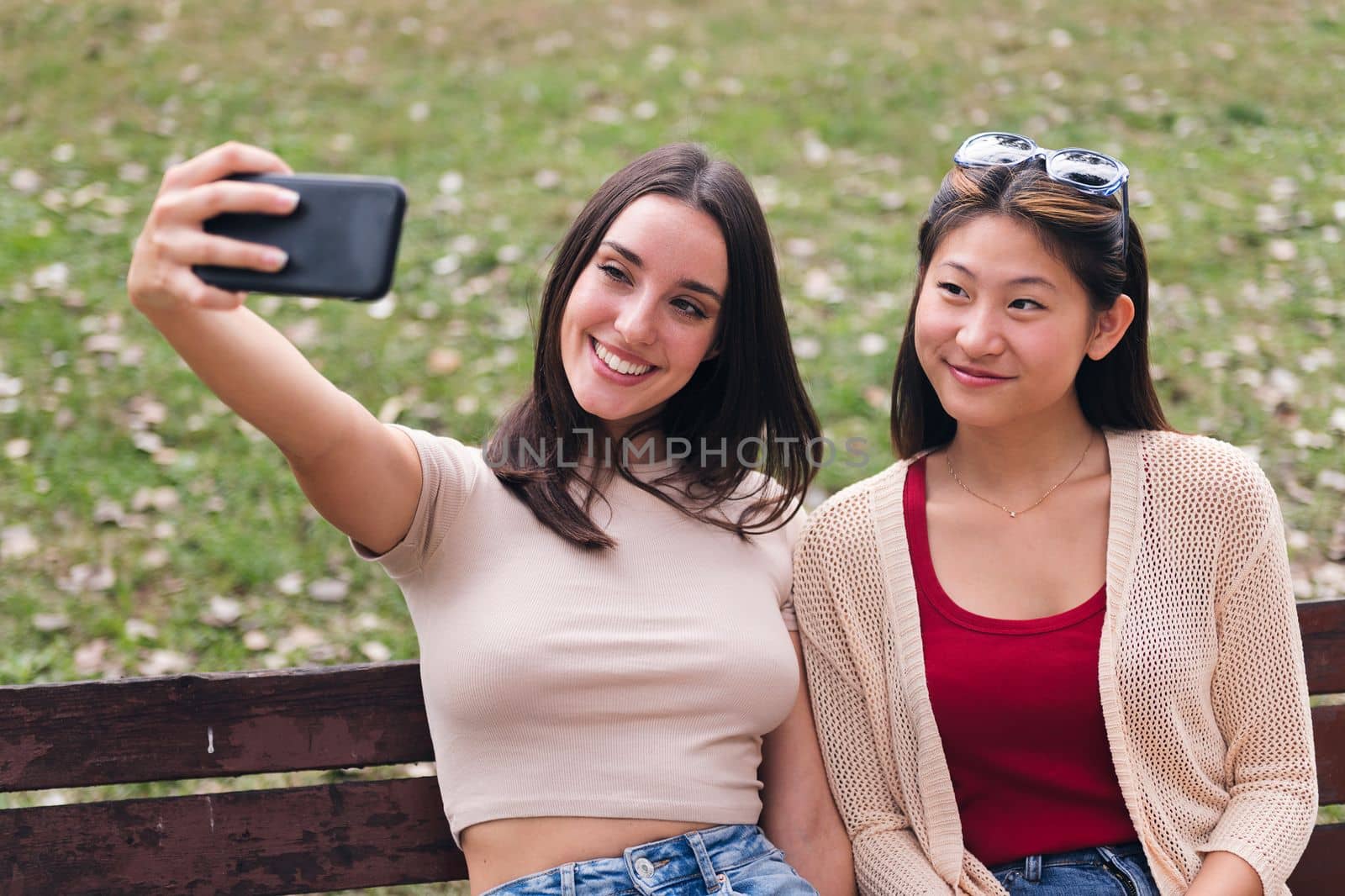 two young women smiling happy while taking a photo by raulmelldo