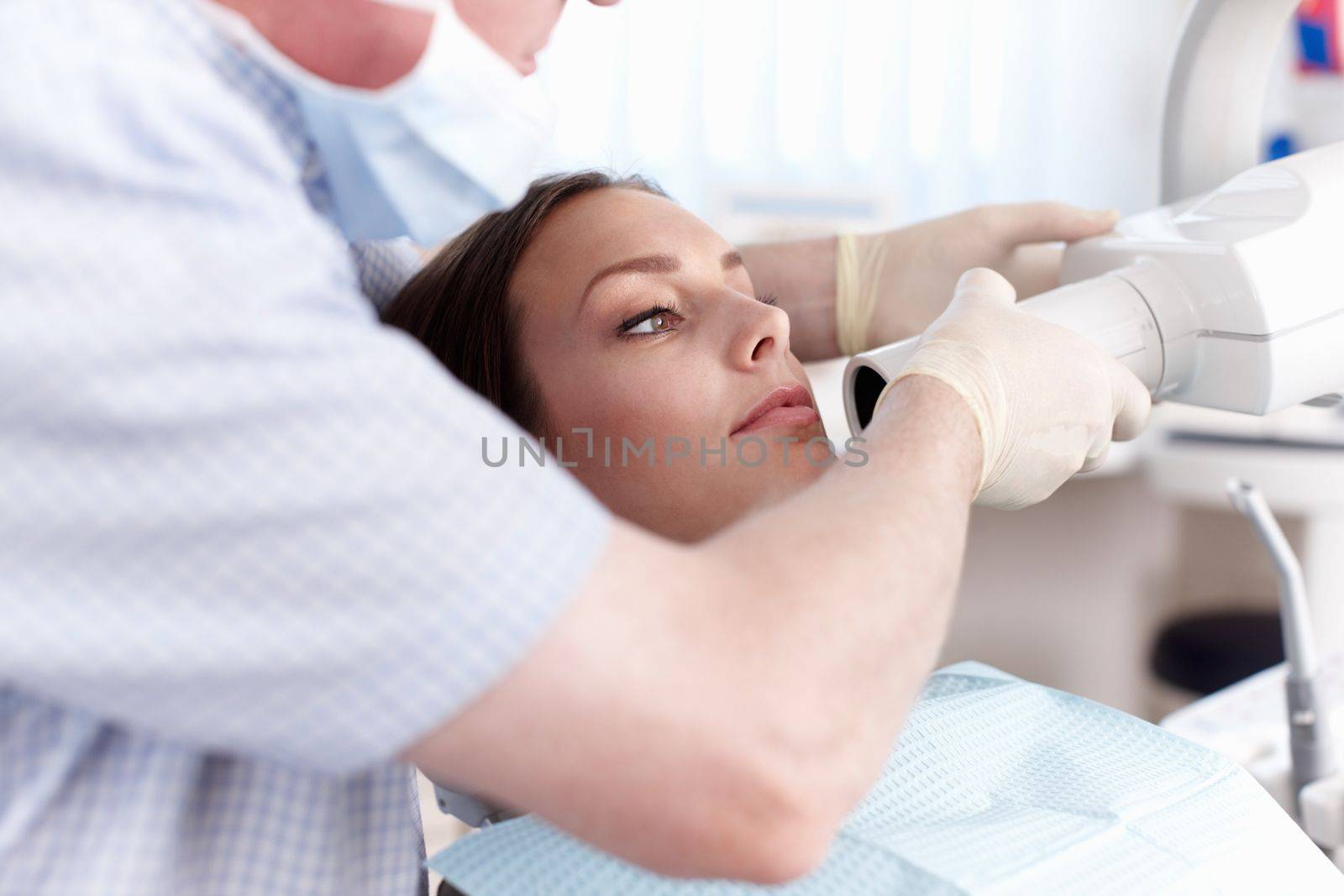 Female patient going through dental treatment. Portrait of female patient going through dental treatment in clinic