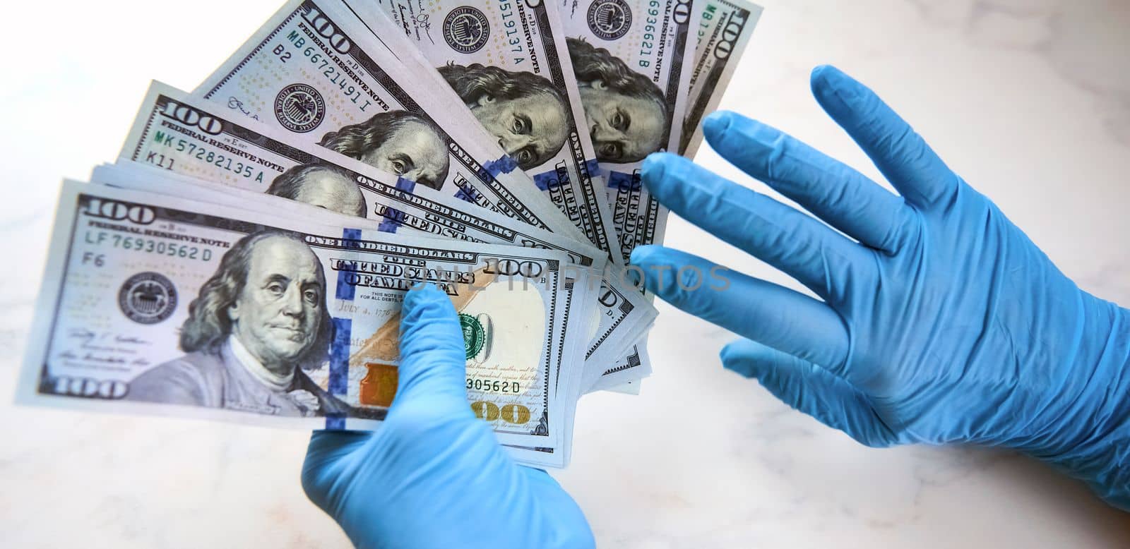 secure money transfer. hand in a rubber glove takes money. hands in sterile medical gloves.