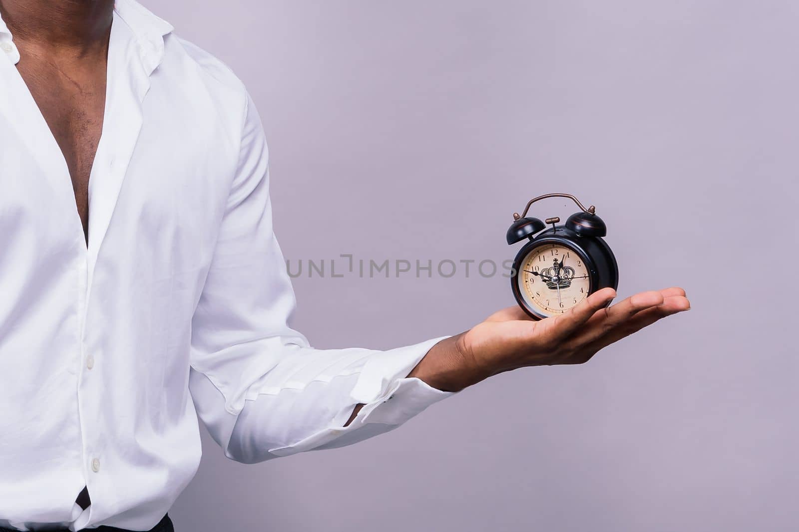 Time Management Concept. Shocked black man holding wall clock, running out of time. by Zelenin