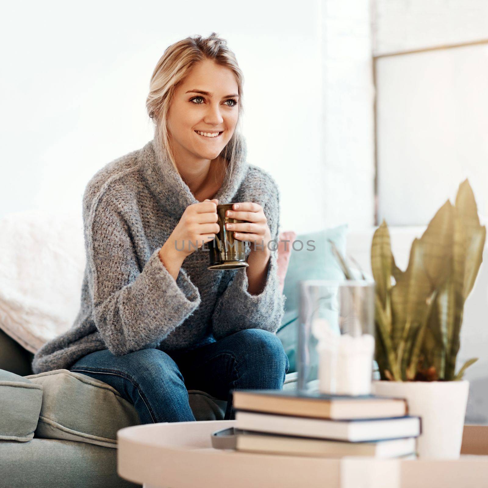 Woman relax in living room, coffee and smile, peace on sofa and content at home with lifestyle and happiness. Female in apartment, happy woman and coffee cup, positive energy and wellness mindset by YuriArcurs