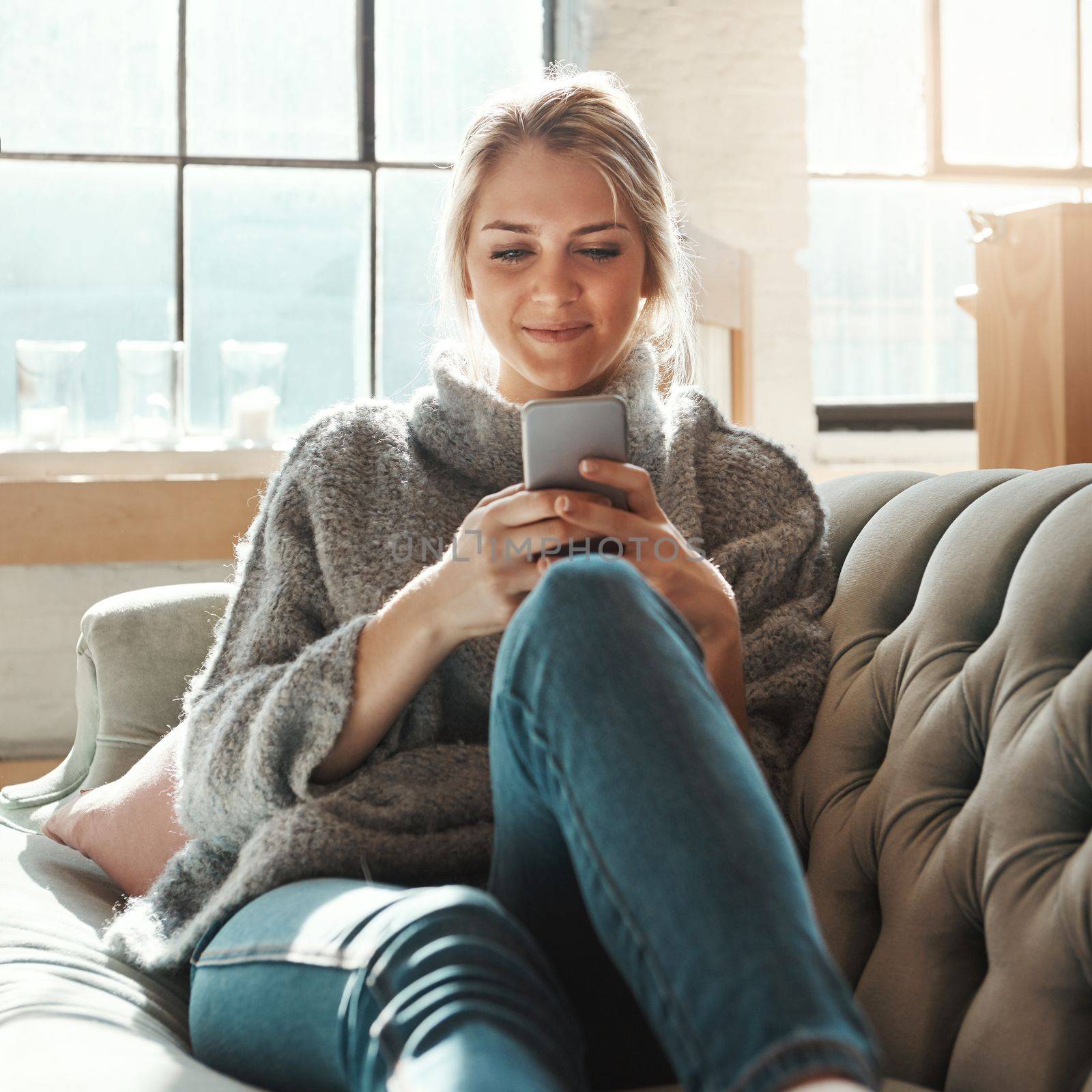 Woman, sofa and smartphone on social media, reading or communication on internet to relax in lounge. Girl, couch and chat with phone, mobile tech or online dating for partner, love or romance in home.