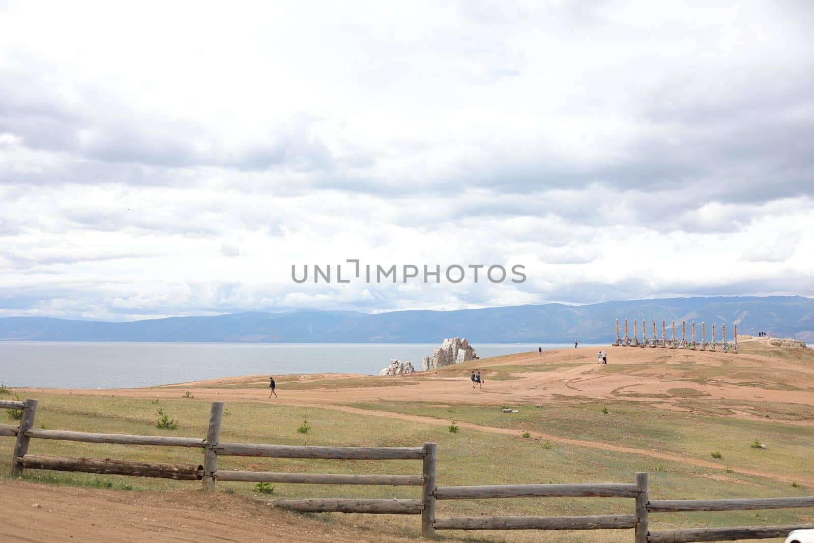 Shaman Stone, visible in the distance on Olkhon Island against the blue sky and Lake Baikal