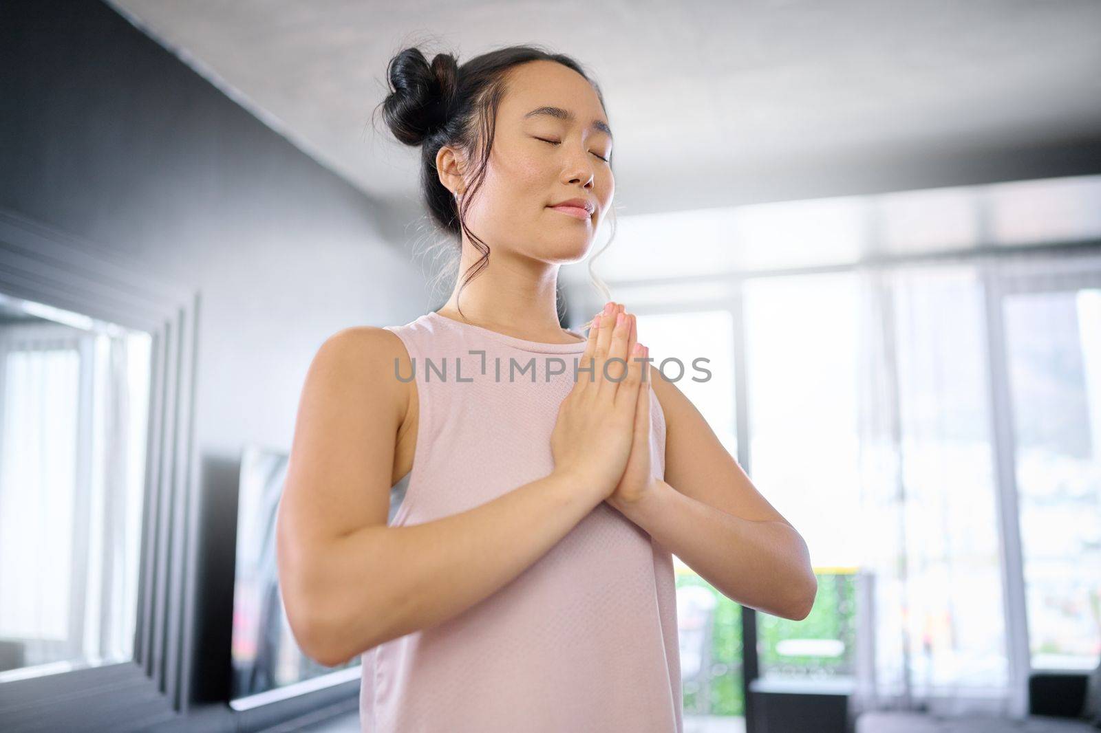 Yoga, meditate and woman with gratitude for her mind, peace and calm start to the morning. Hope, freedom and Asian girl in the living room for a mindset exercise, spiritual faith and mindfulness by YuriArcurs