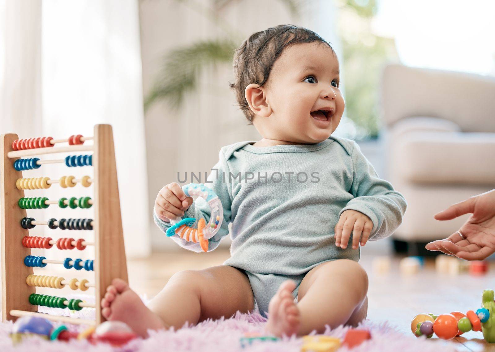 Babies know how to have a good time. an adorable baby playing with toys at home. by YuriArcurs