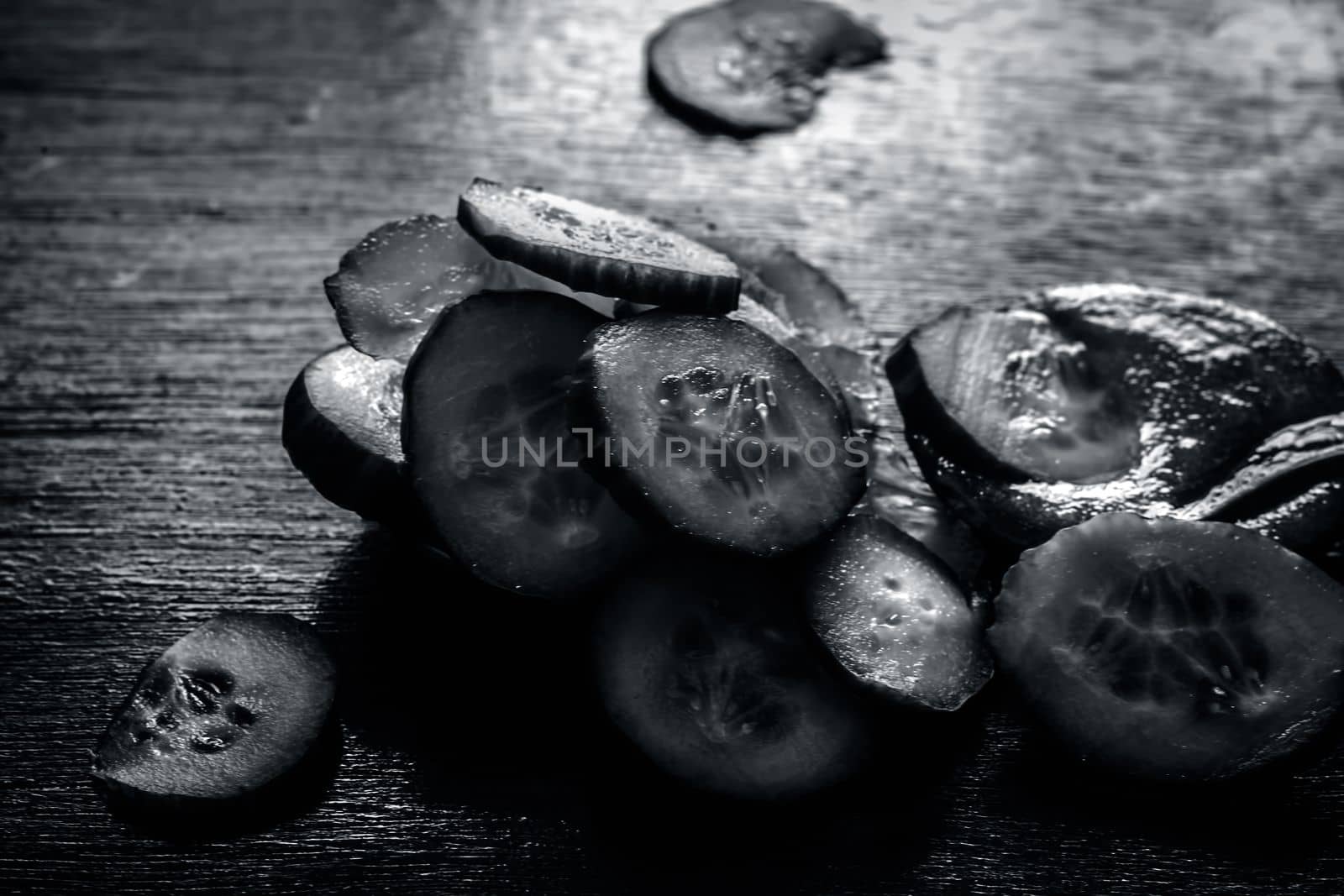 Close-up of ingredients of facial or face pack or face mask on a wooden surface i.e. slices of cucumber and Aloe Vera in dark Gothic colors for brightening and softening the skin. by mirzamlk