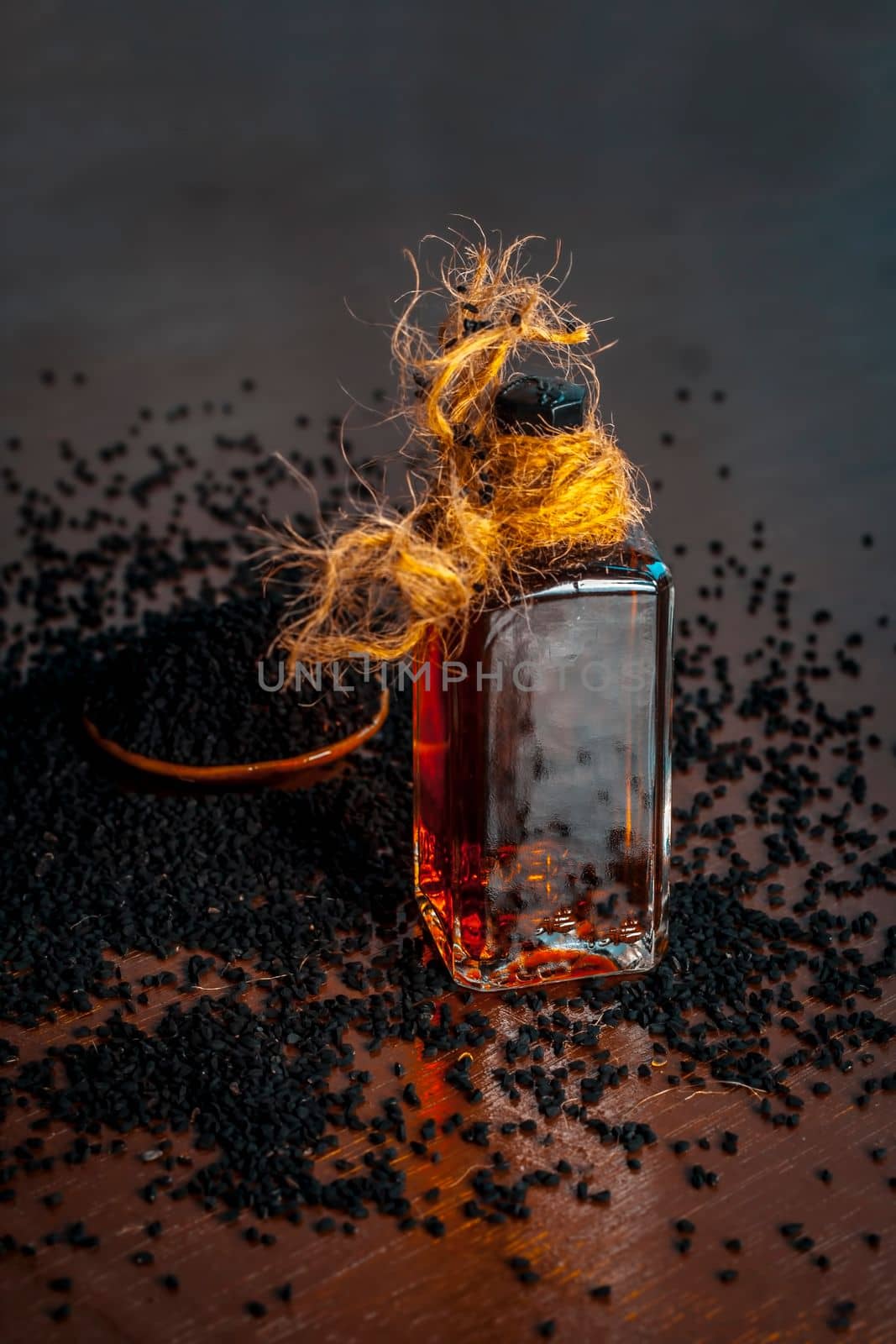 AYURVEDIC HERB i.e. Kalonji,black caraway seeds with its beneficial and essential oil on a brown surface in dark Gothic colors.This oil is used in weight loss,lowing the blood sugar/diabetes etc. by mirzamlk