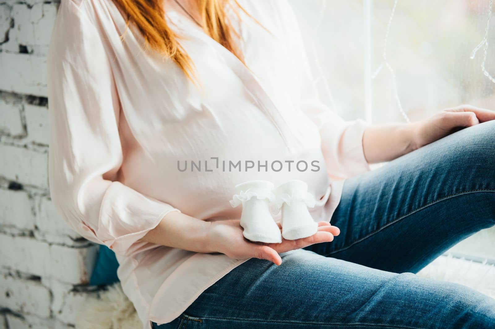 red-haired pregnant girl in a light blouse and blue jeans by Andreua