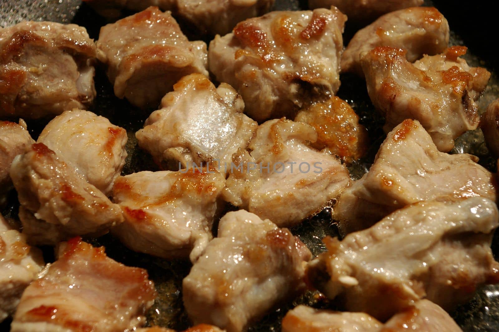 Close up Pork bone fried in a cooking pan with garlic