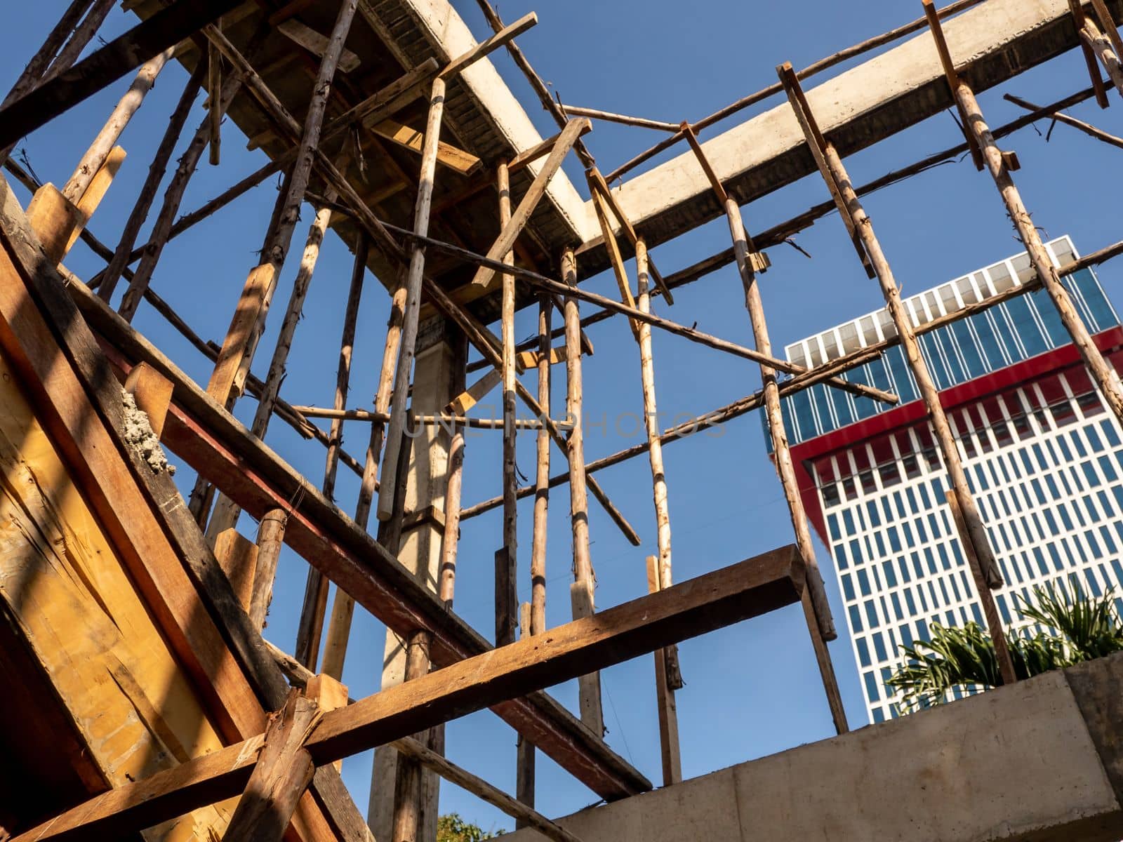 Temporary wooden pole for supports the concrete structure a building under construction