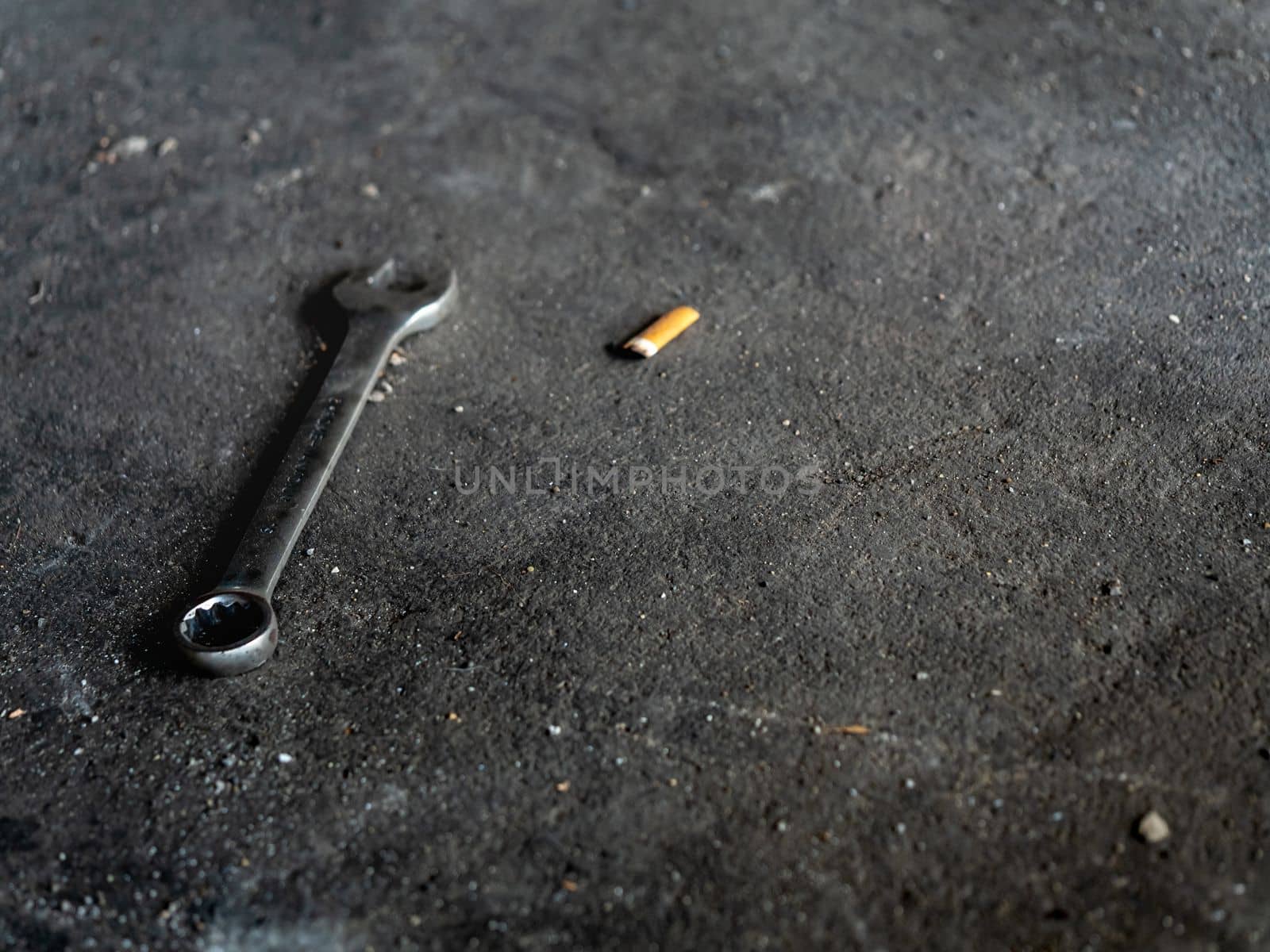 The Combination wrench on the rough concrete flooring by Satakorn