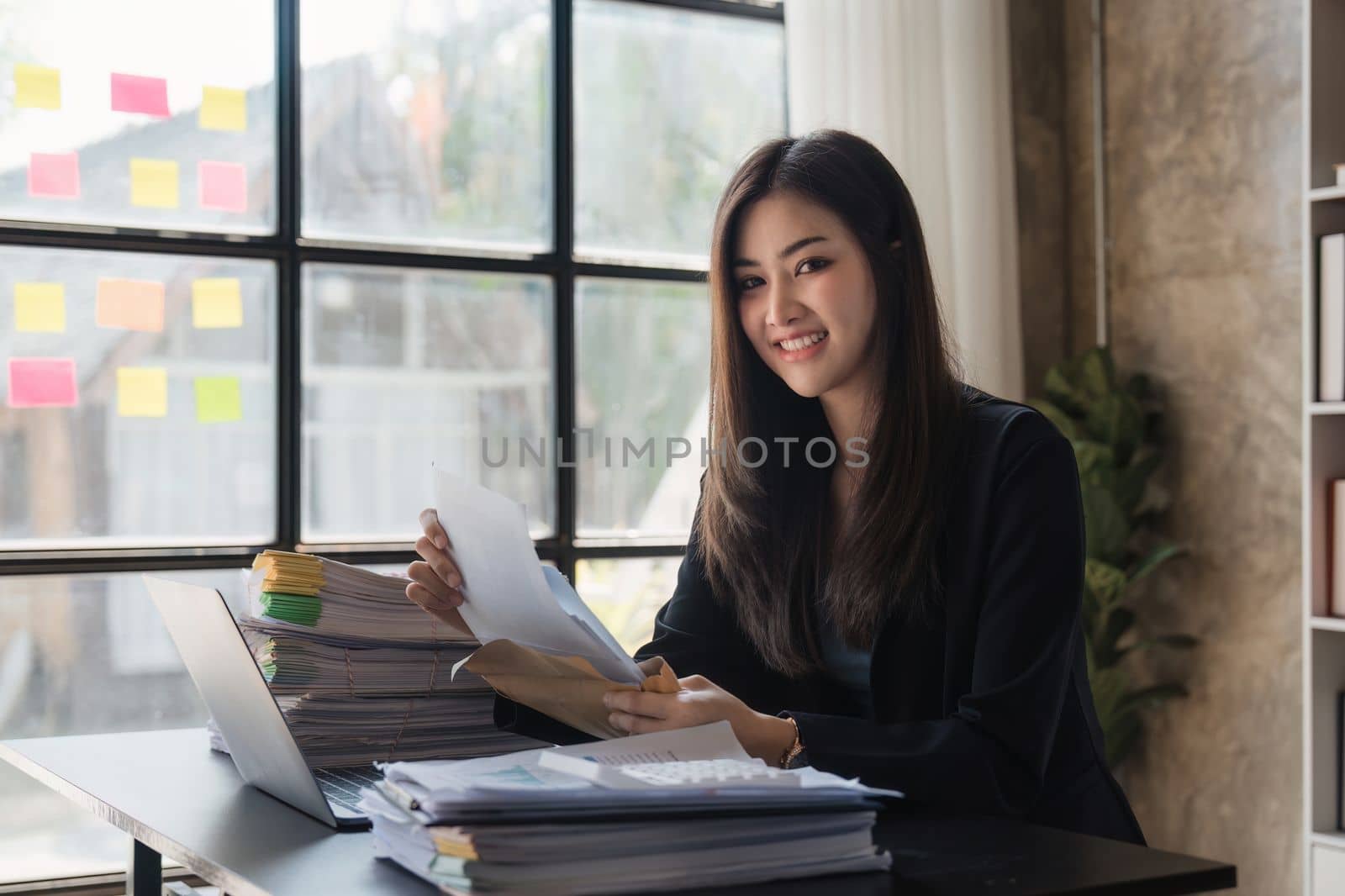 Beautiful Business woman working at home office and analyze financial report document. Accounting and Finance concept by itchaznong