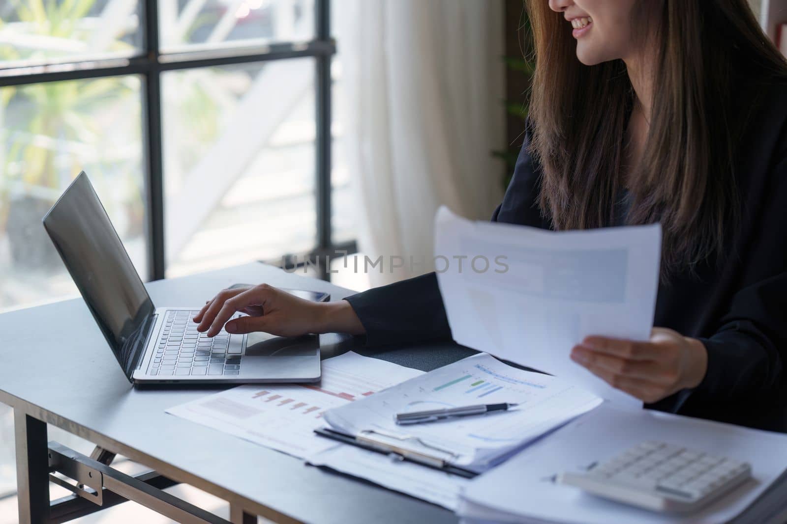 Beautiful Business woman working at home office and analyze financial report document. Accounting and Finance concept.