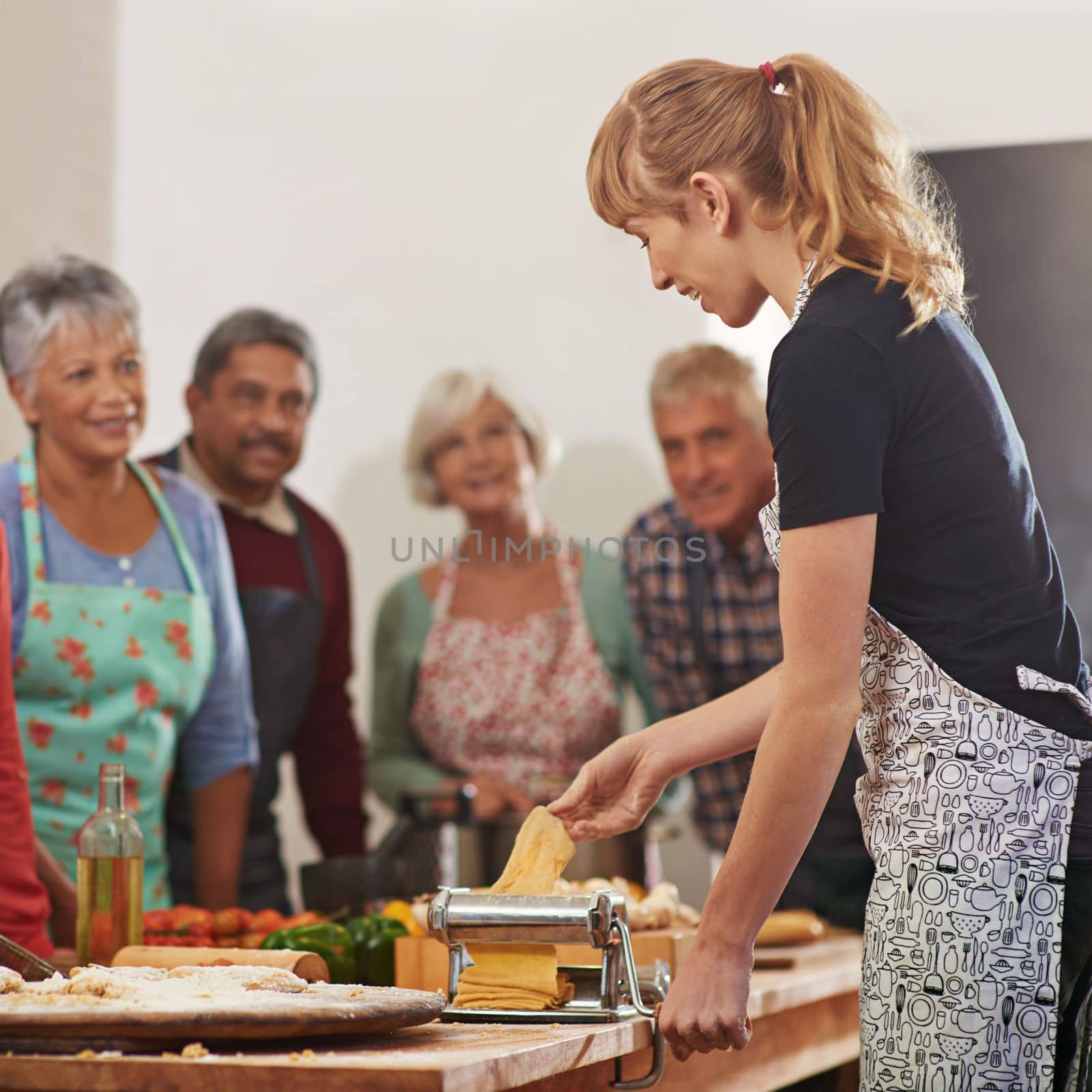 Showing them how to trim their grocery bill. a woman showing her class how to make pasta. by YuriArcurs