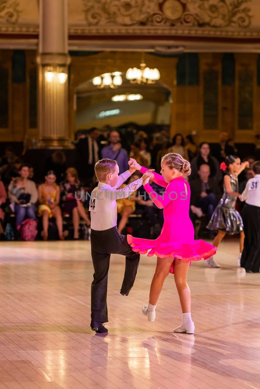 Attractive young couple of children dancing ballroom dance. Girl and boy dancer Latino international dancing.