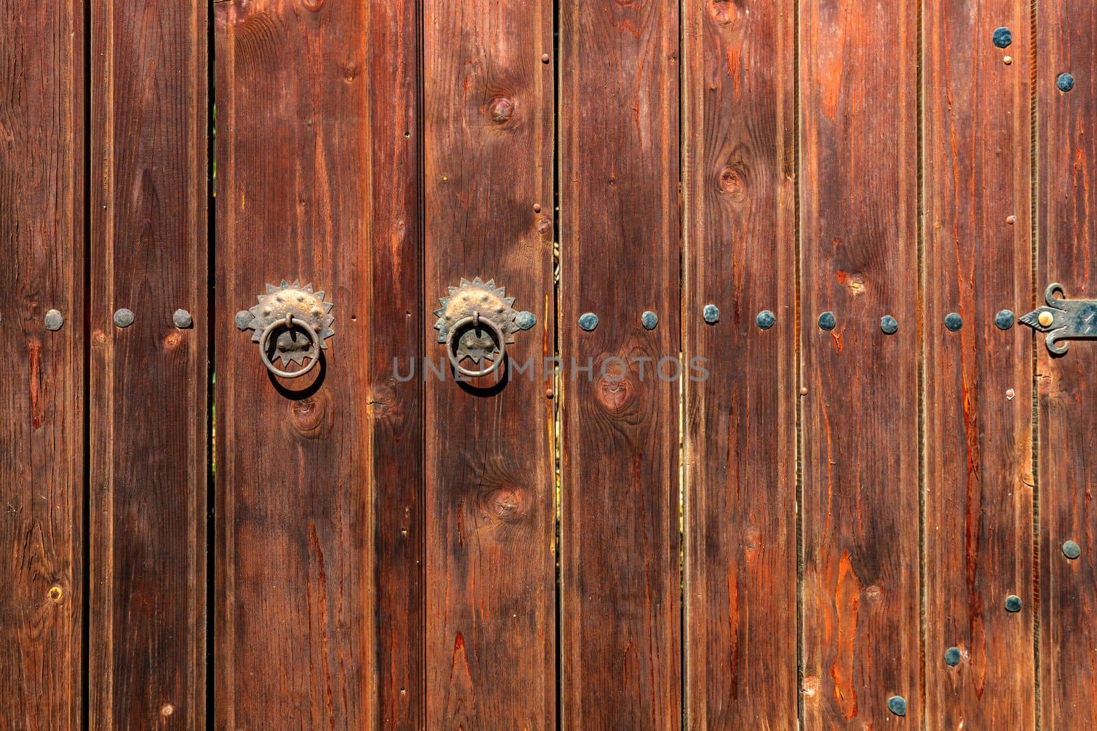 Old vintage wooden door ornate with a beauty metal furniture. Close up