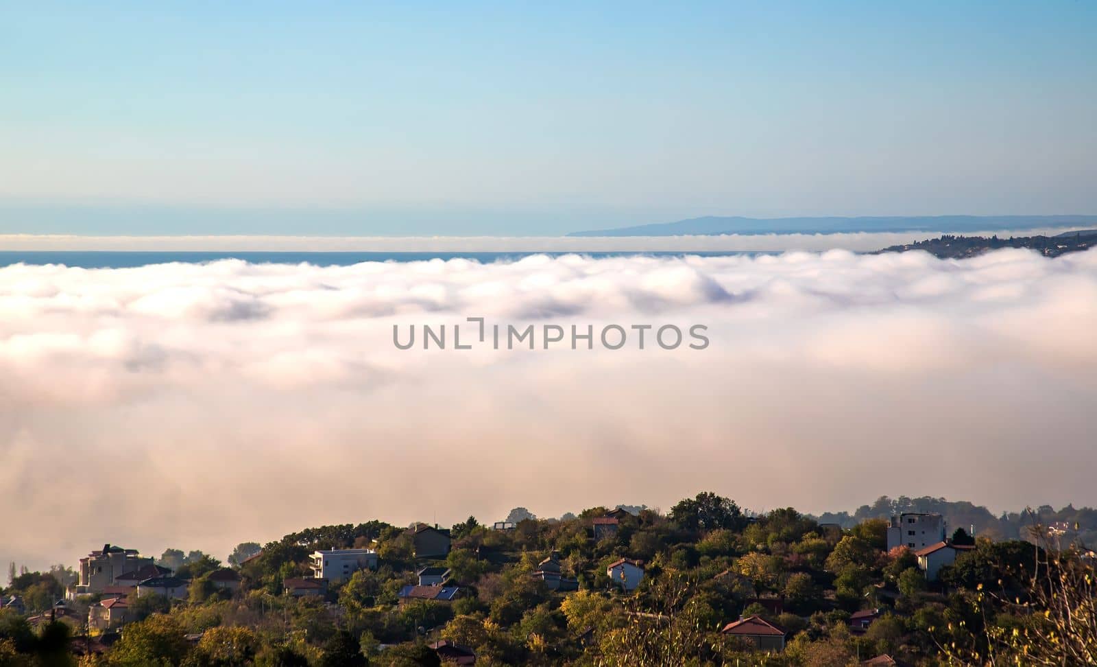 Fog clouds over the city from the sea, view from above